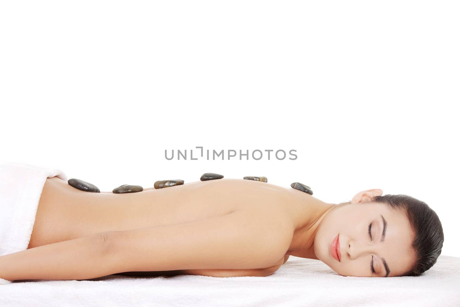 Beauty woman relaxing in spa. Stone massage.