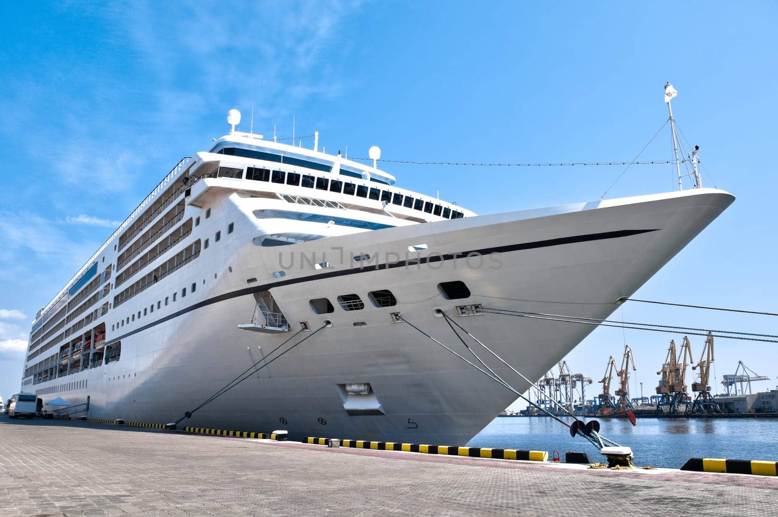 beautiful white giant cruise ship on stay at harbor, blue cloudy sky in background
