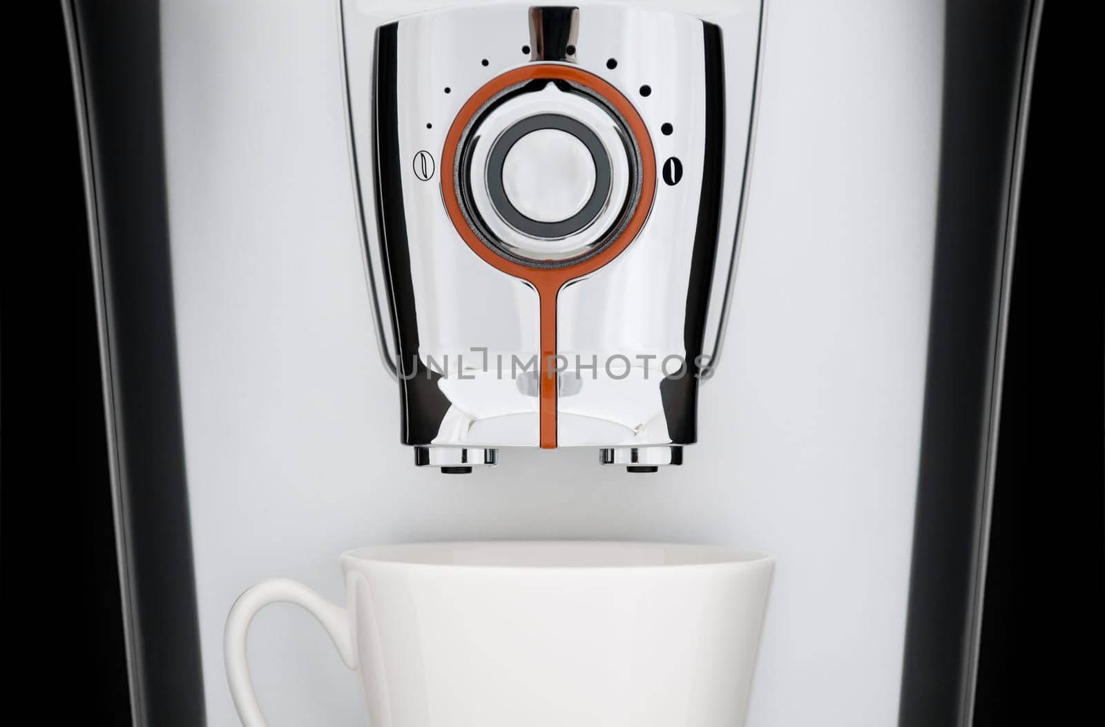 close up front view of modern automatic espresso coffee machine. White cup under nozzle, black background
