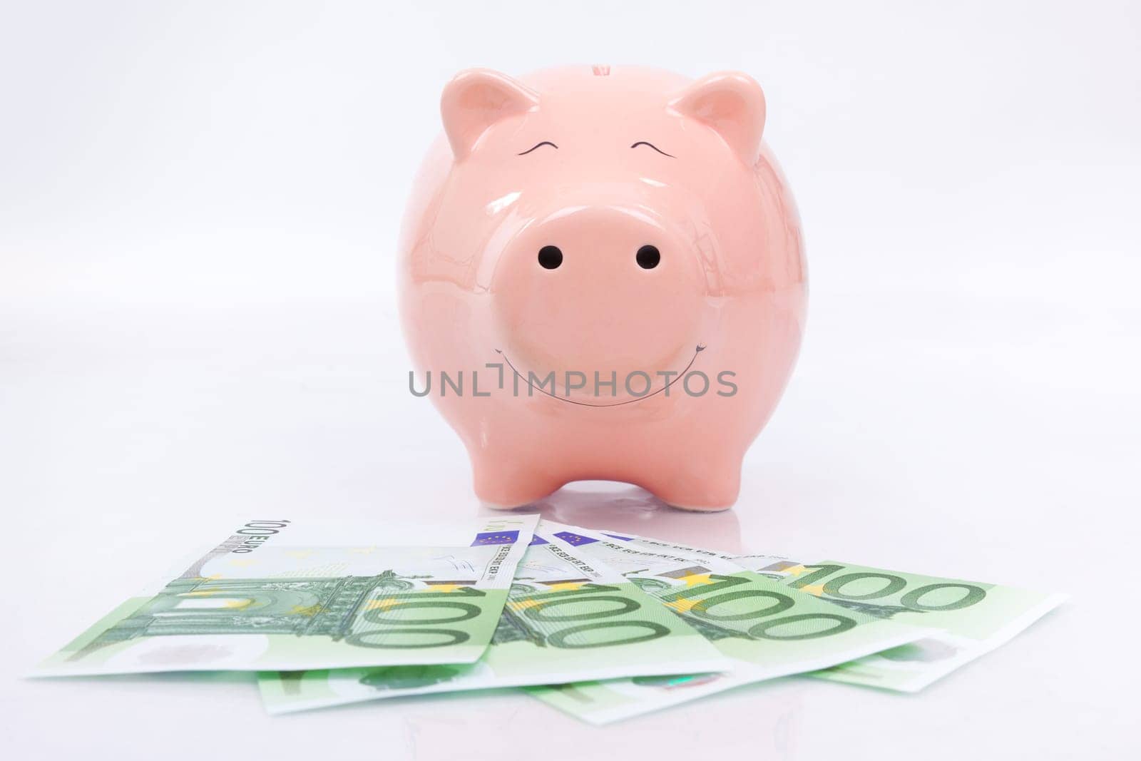 Piggy bank with euro bills isolated on white background