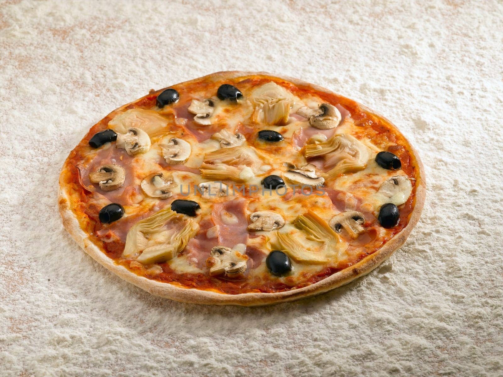 A tasty pizza cappriciosa on a bed of flour.