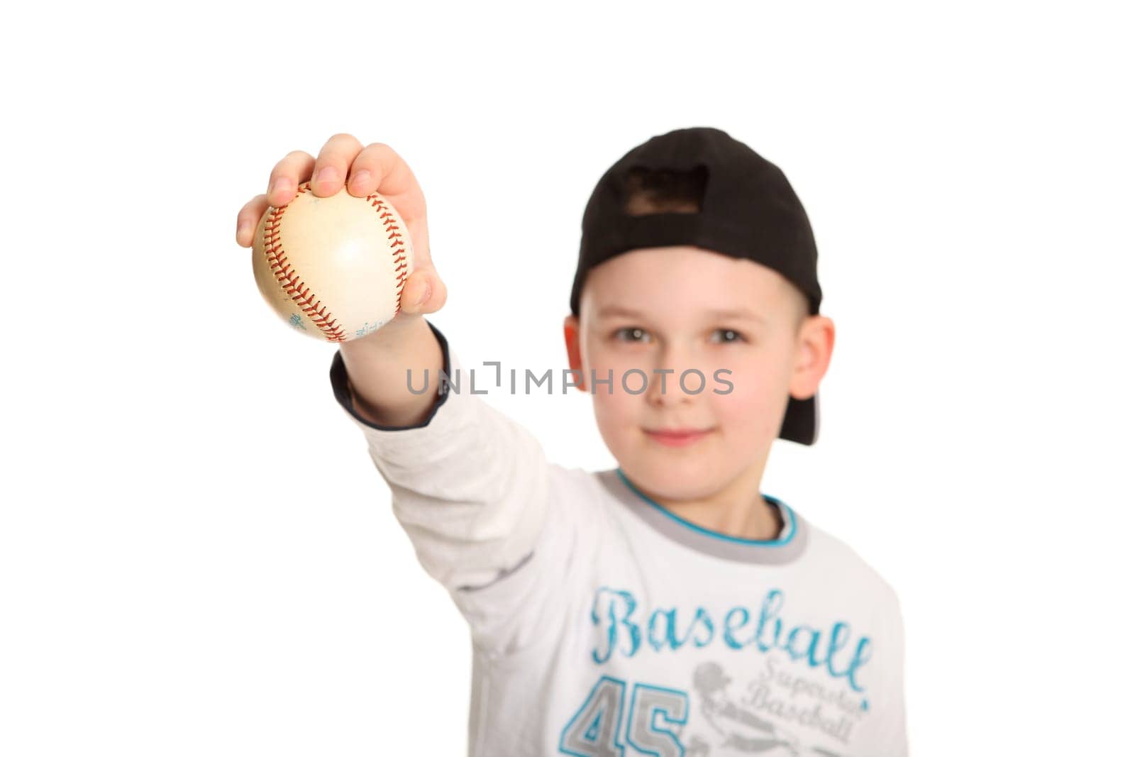 The photo shows a little boy holding a baseball stretched out in front of the camera.