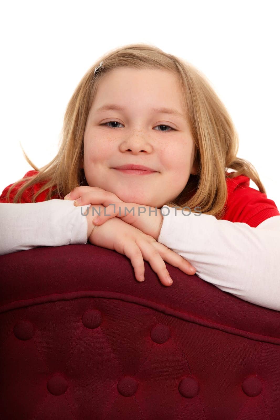 Portrait photo of a girl resting on her hands with her chin and looking kindly into the camera