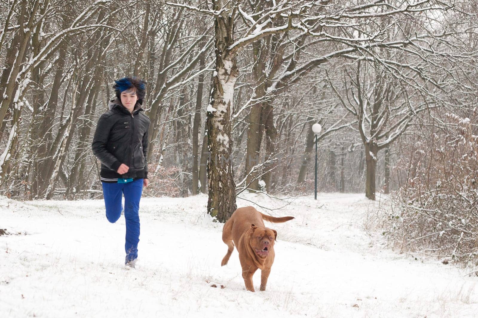 Funky boy is having fun with his dog in the snow