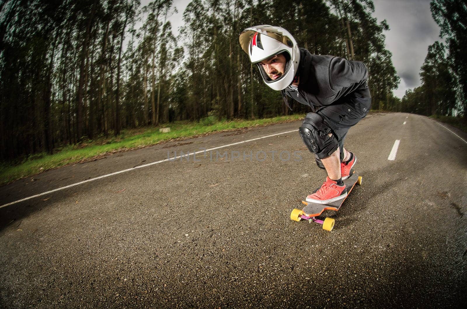 Downhill skateboarder in action on a asphalt road.