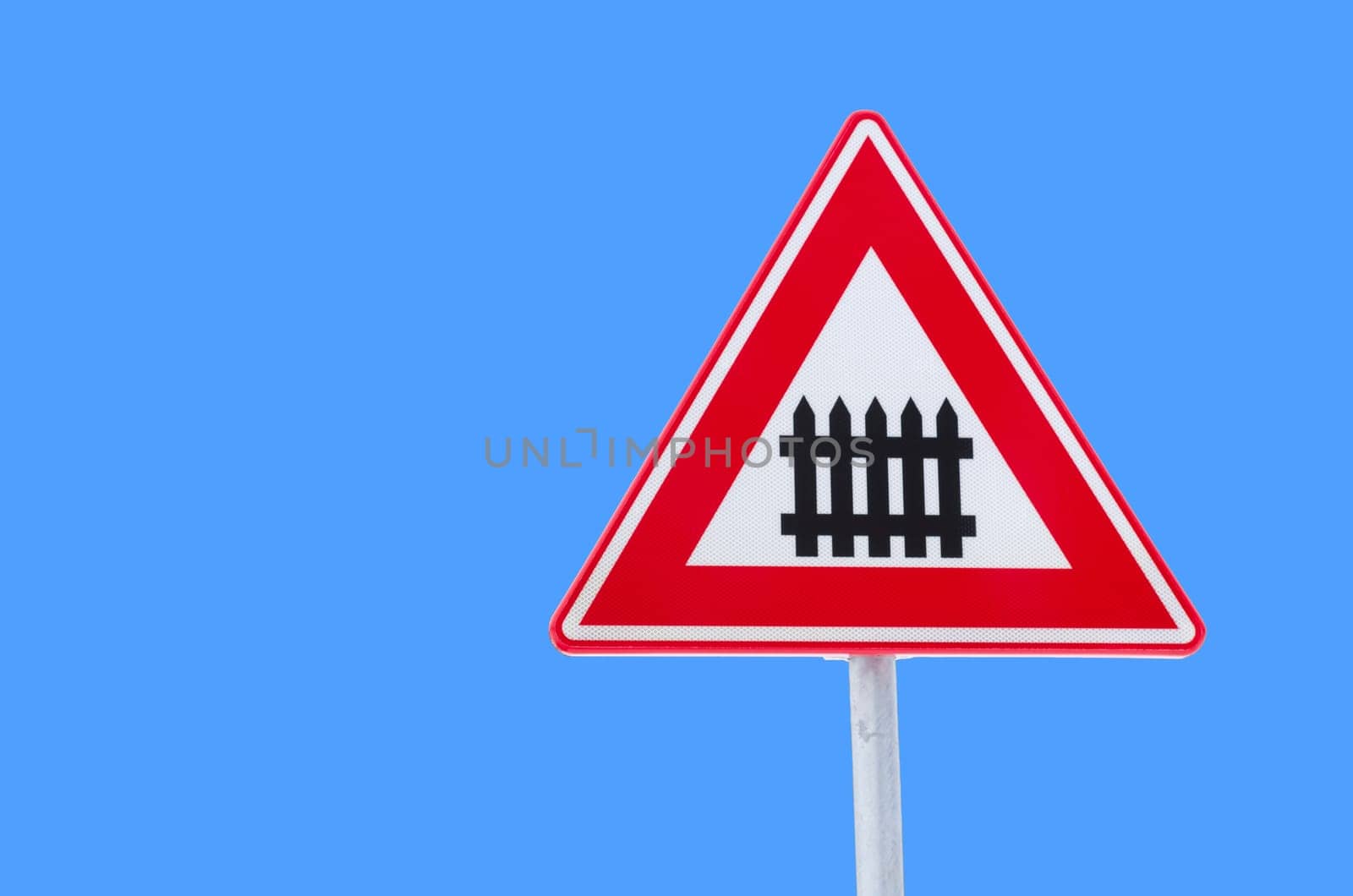 isolated traffic sign approaching a railroad secured with automatic gate