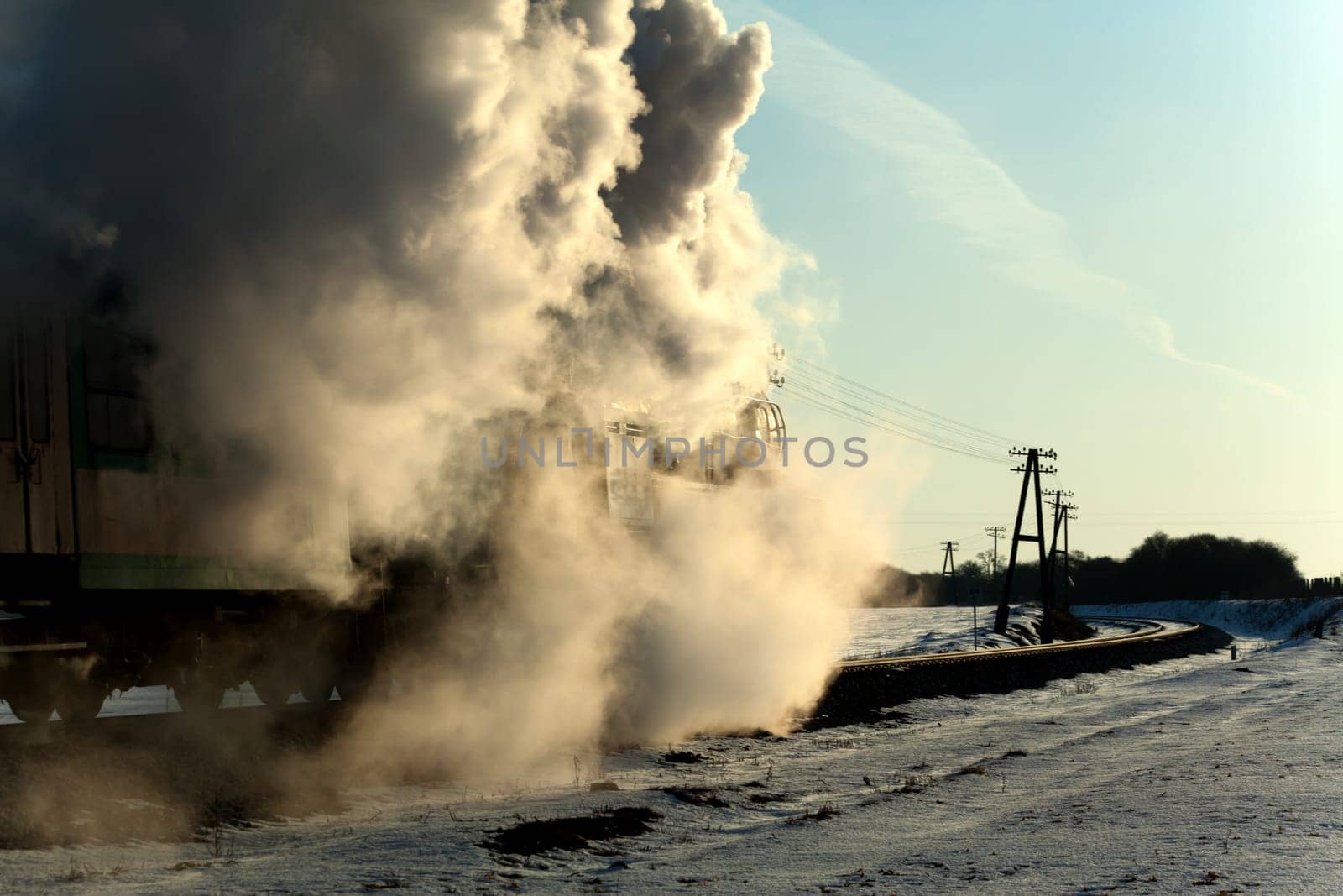Vintage steam train puffing through countryside during wintertime