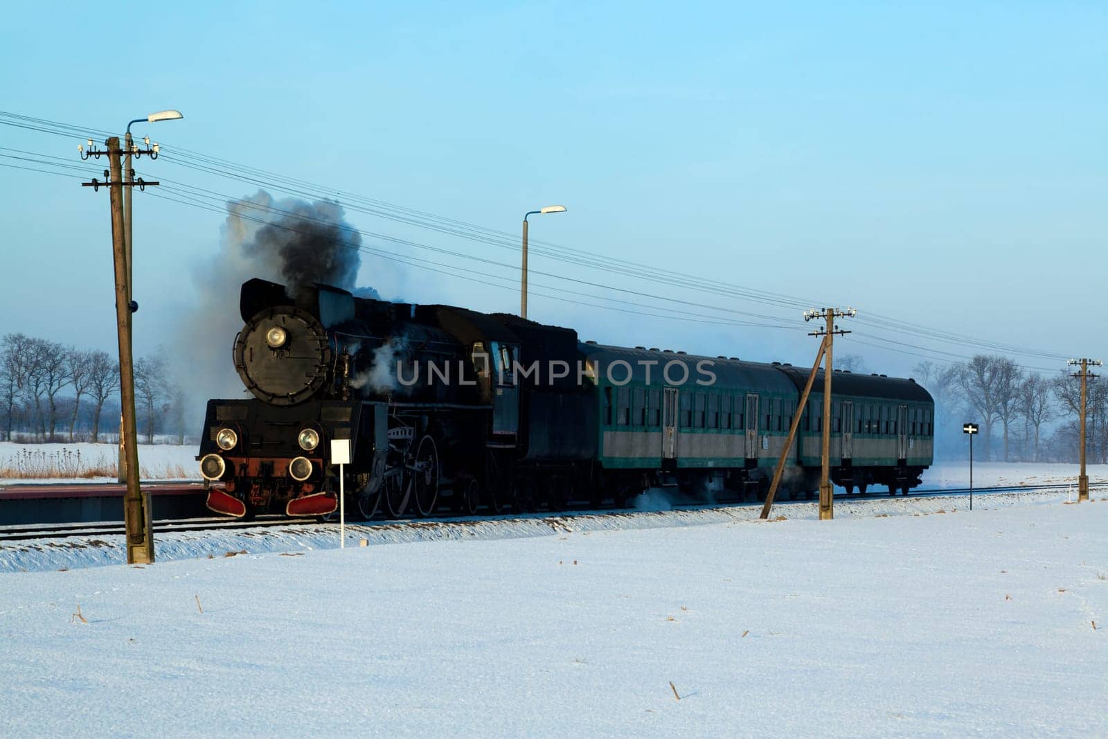 Vintage steam train puffing through countryside during wintertime