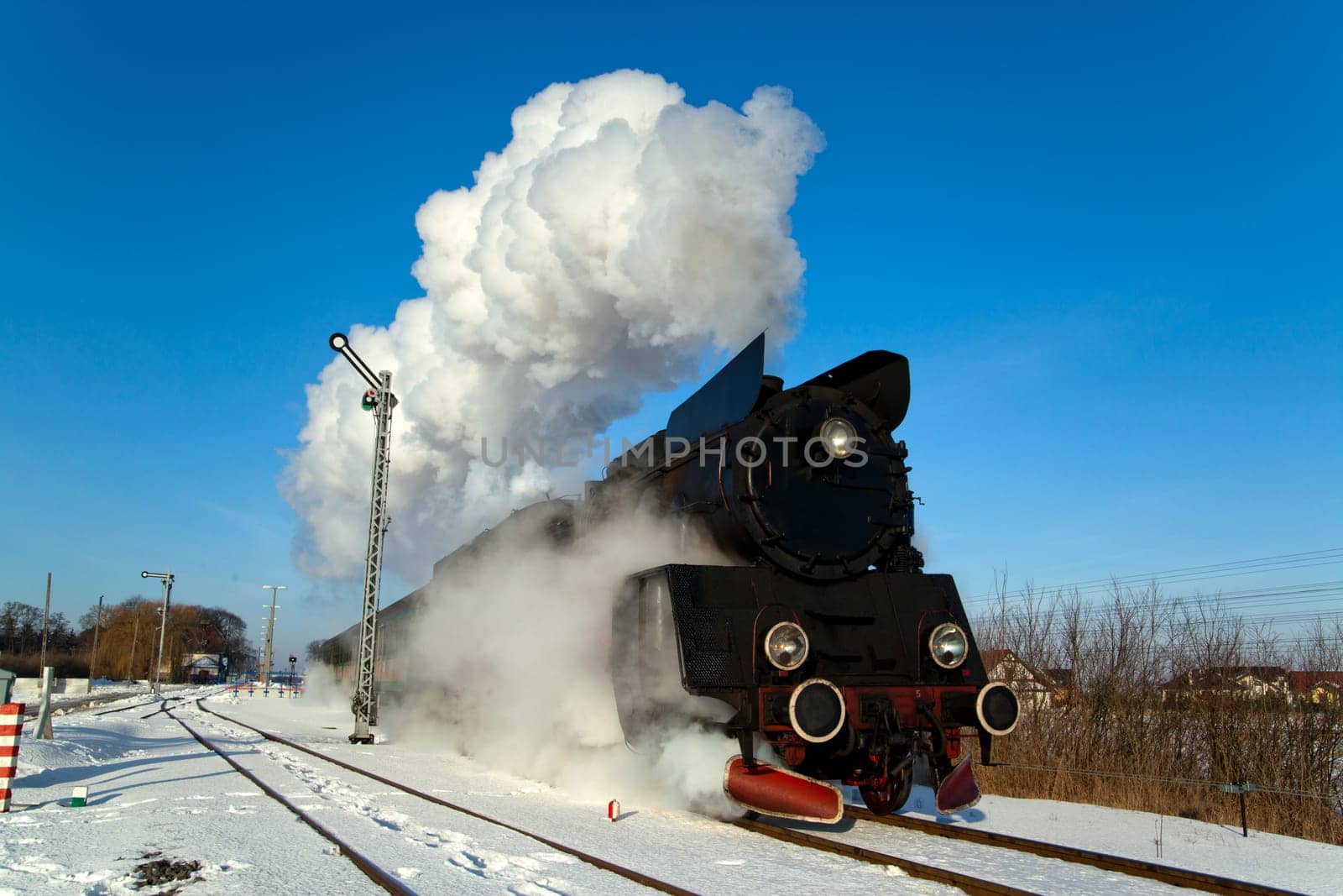 Vintage steam train puffing through countryside during wintertime