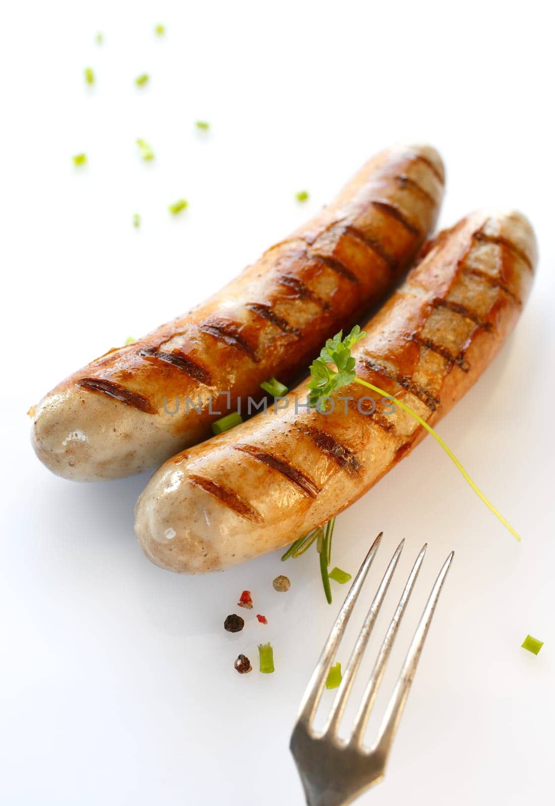Two grilled sausages and fork in a close up shot