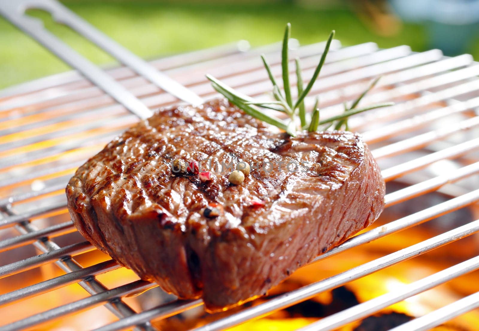Grilled marinated steak on the grilling pan with open flames
