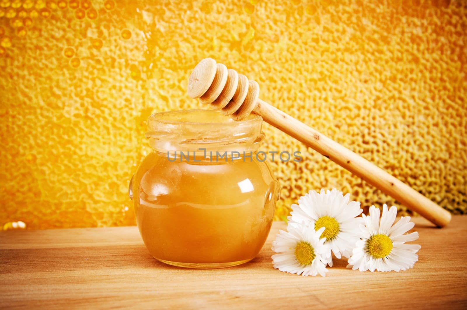 Jar of honey and flovers. On the background of honeycombs