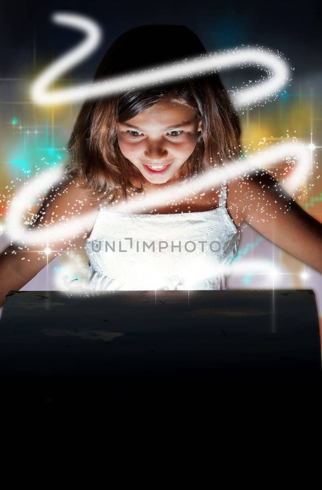Little girl opening the magic chest and setting rays of magic glowing light free. Christmas or birthday concept  the magic of gifts and the imagination.