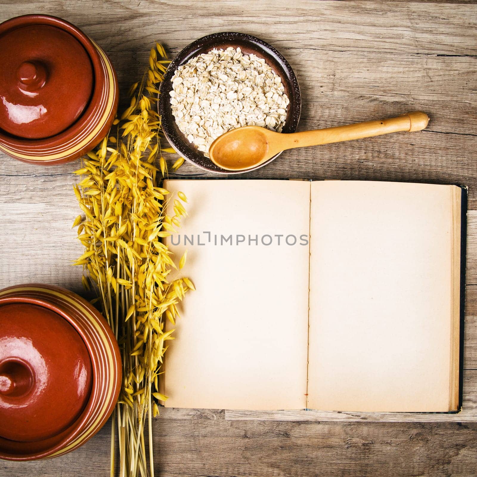 The top view on the opened cookbook and kitchen utensils