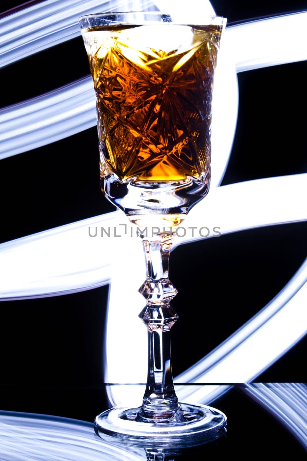 photo of the goblet with alcohol with light painted background