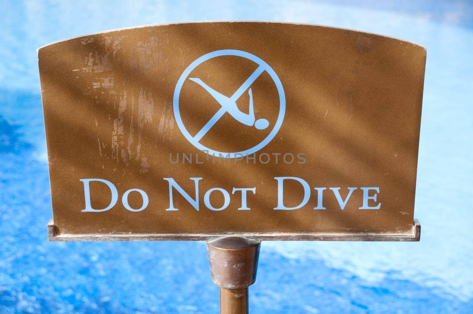 do not dive sign with blue water in background