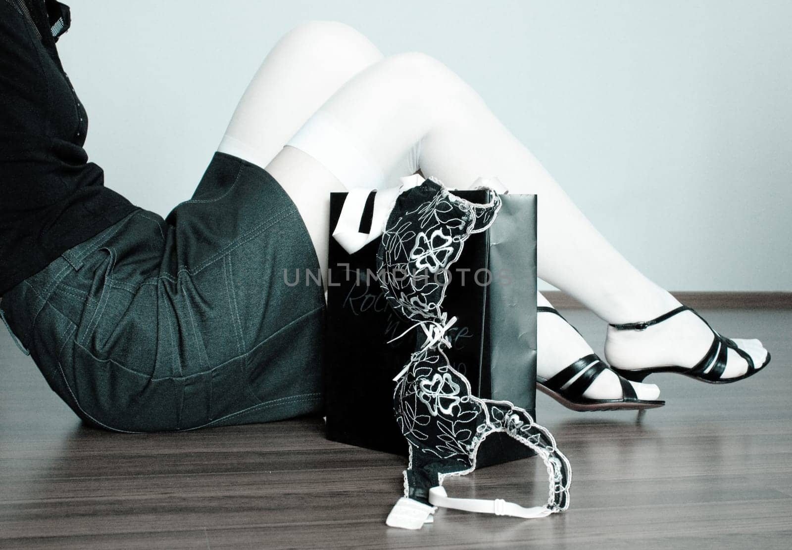 photo of the girl in stockings sitting on the floor with bag near legs