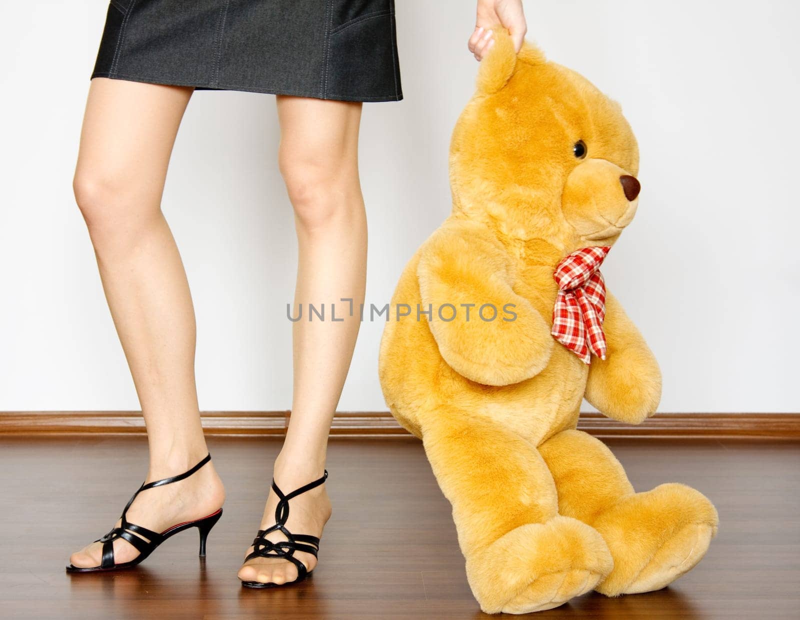 sepia photo of the toy bear between girl legs