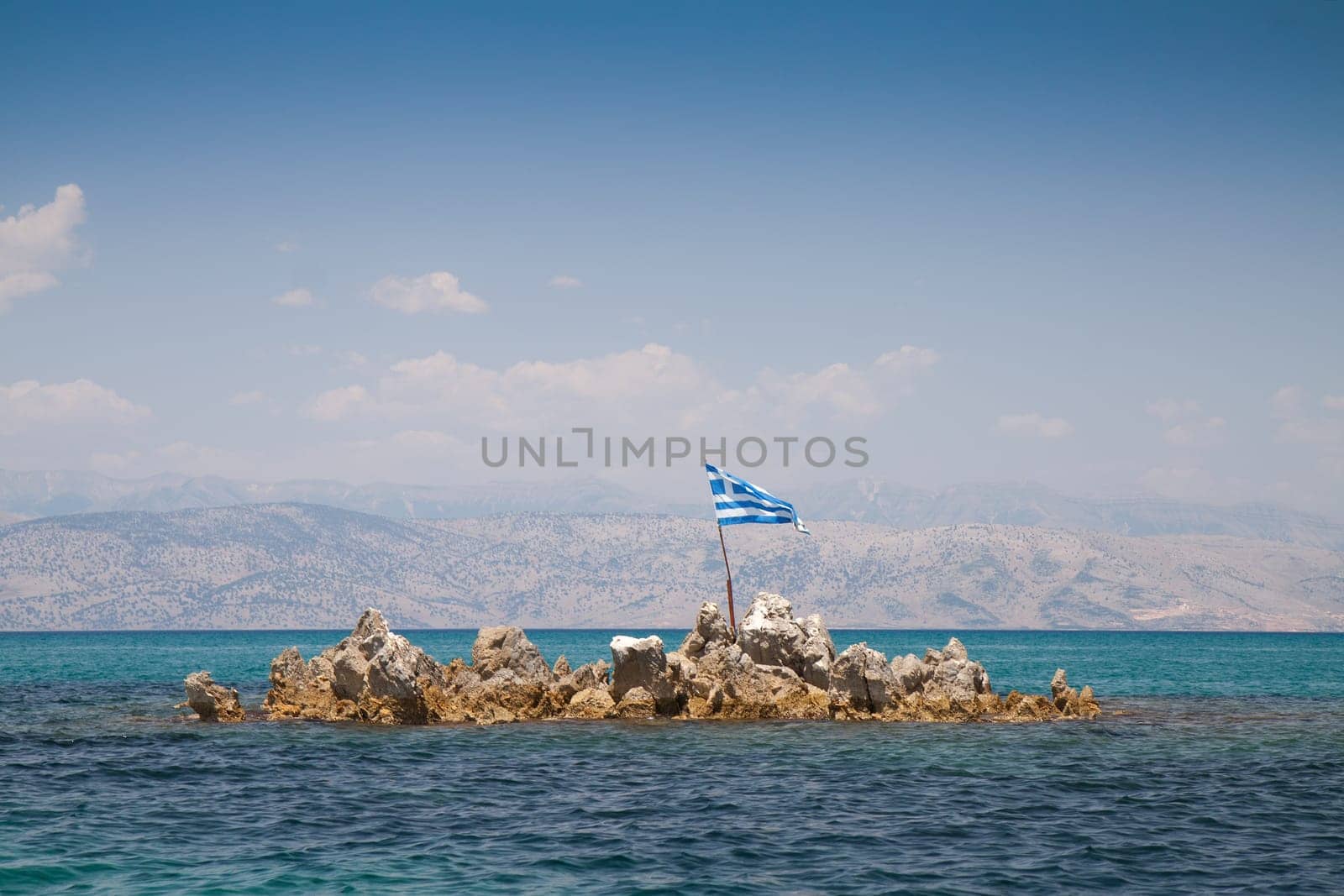 Greek flag on the rocky island near Corfu