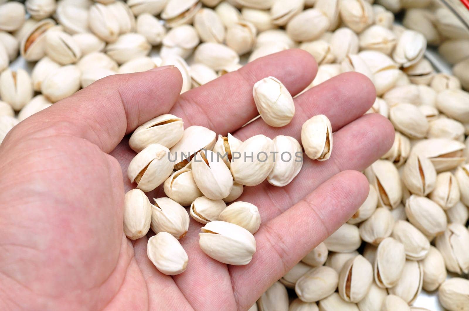 Open hand showing pieces of pistachio nuts