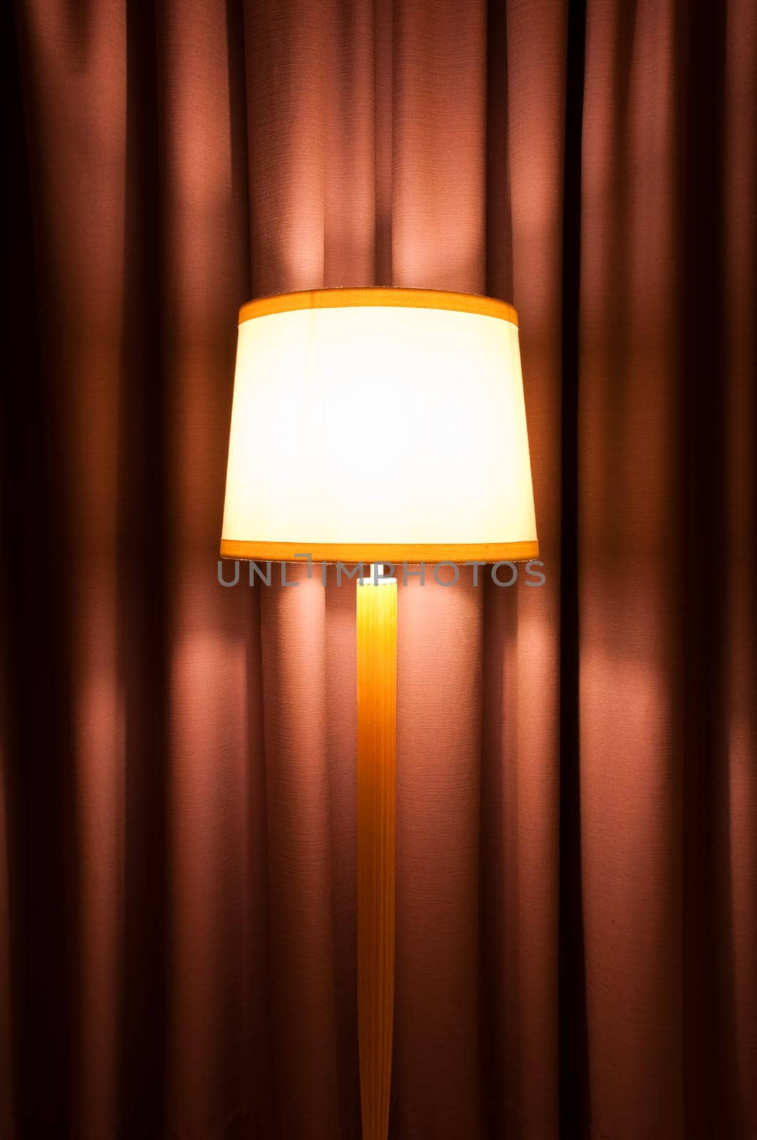 cozy interior with lamp on stand against curtain