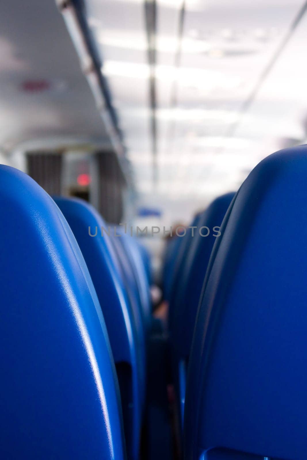 modern plane interior bith blue seats in foreground