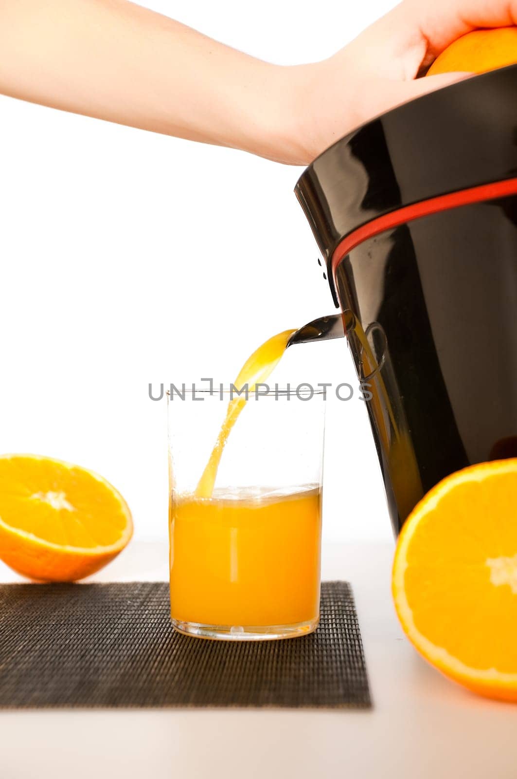 making orange juice from sliced oranges with help of juicer