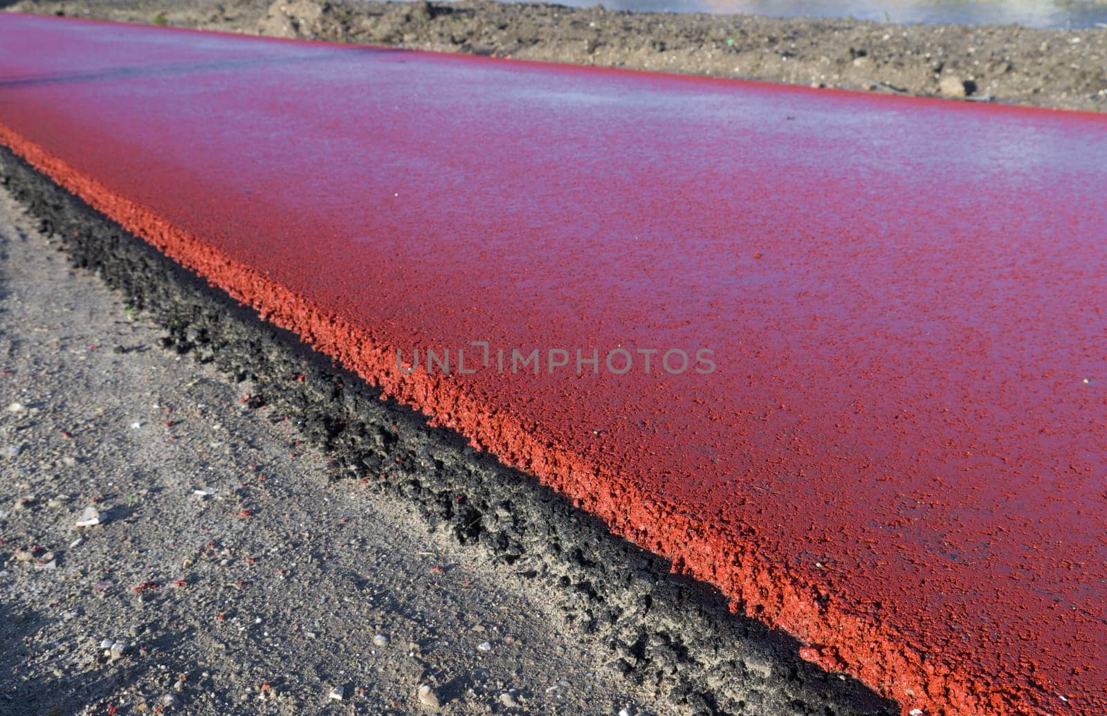newly constructed bicycle lane made of red asphalt