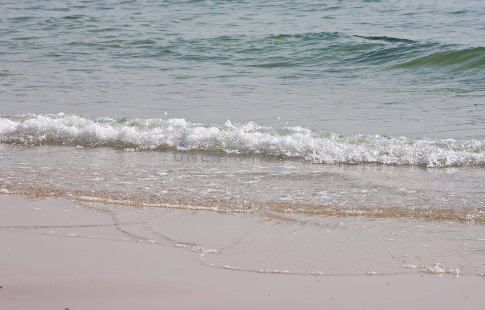 Sea water waving into the beach.