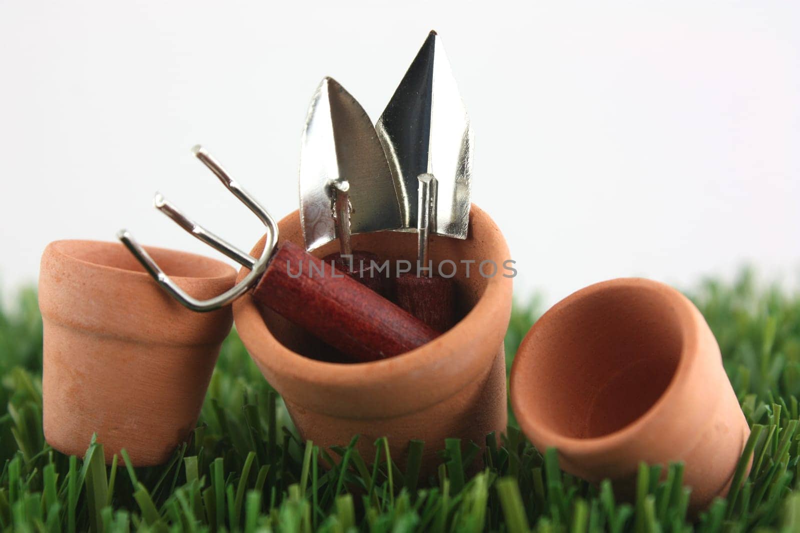 Clay pots on grass with garden tools