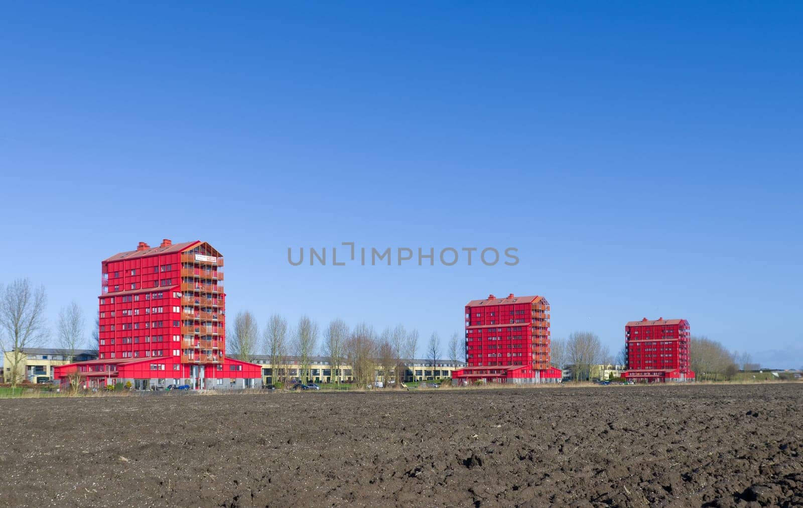modern red apartments in Almere, Netherlands. They are called "red thunders"" and figuring the transition from the outer residential areas to the agricultural polders"
