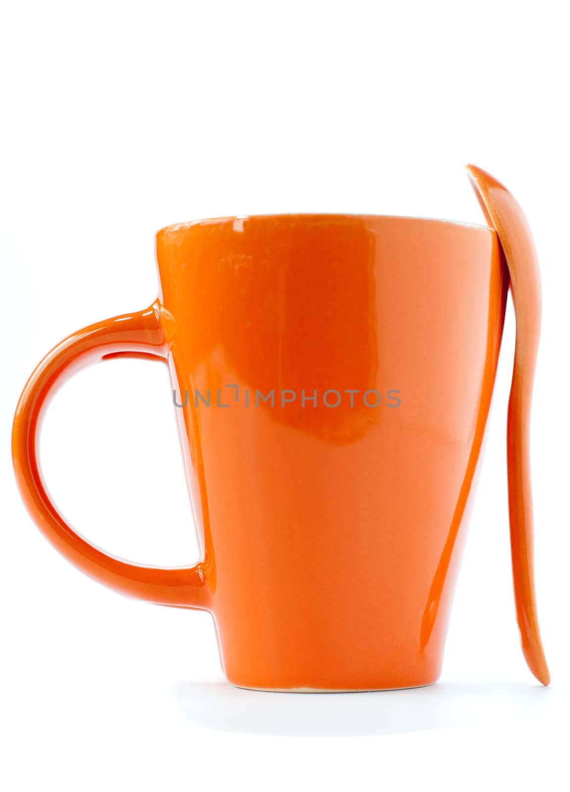 orange empty ceramic cup and spoon isolated on white