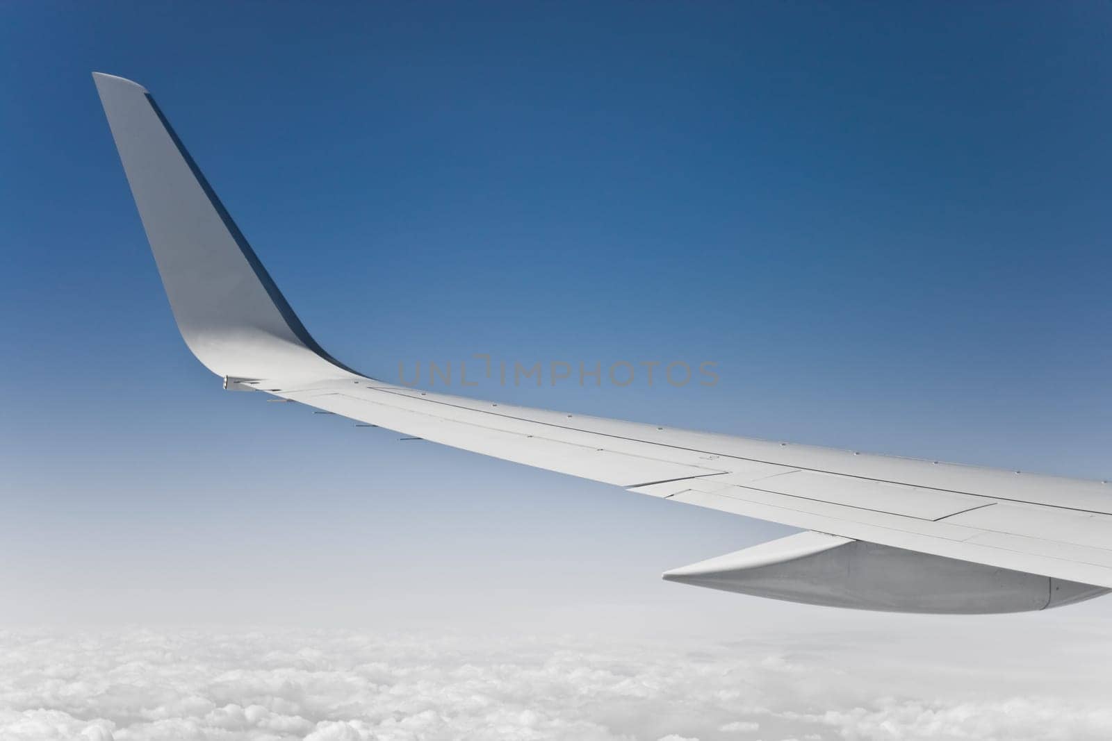 view of the jet plane wing and sky from passenger window
