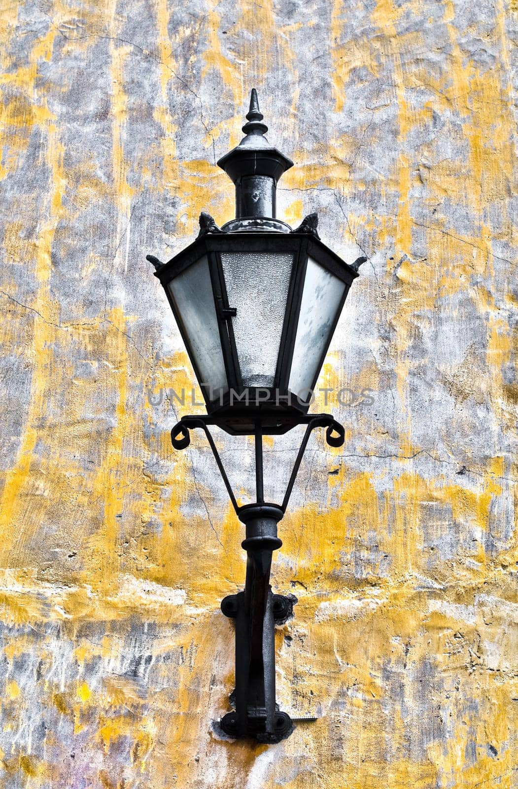old lantern on yellow wall in street of Tallin old town, Estonia