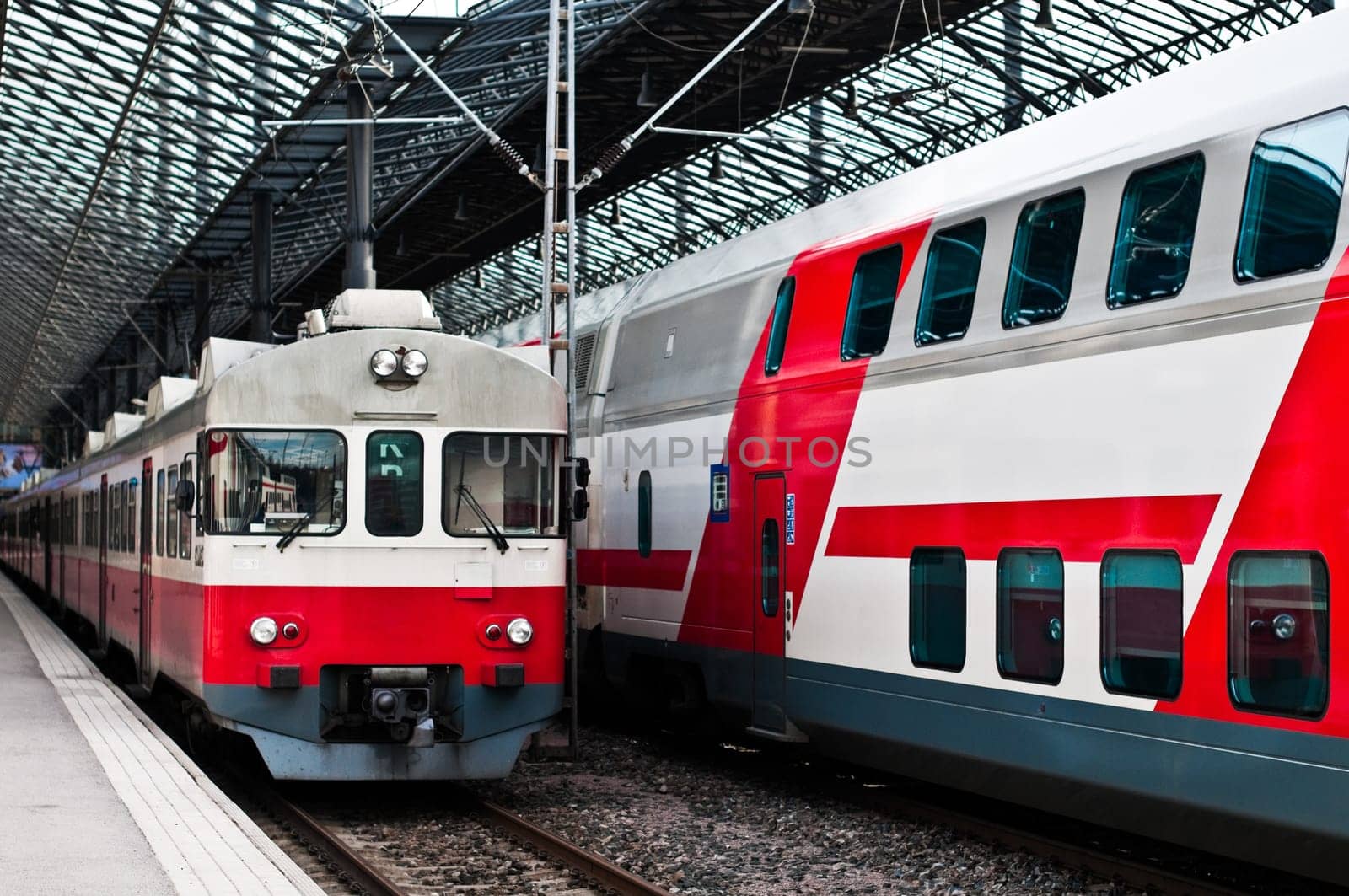 two trains in white and red color, one new and one old model at train station in Helsinki, Finland