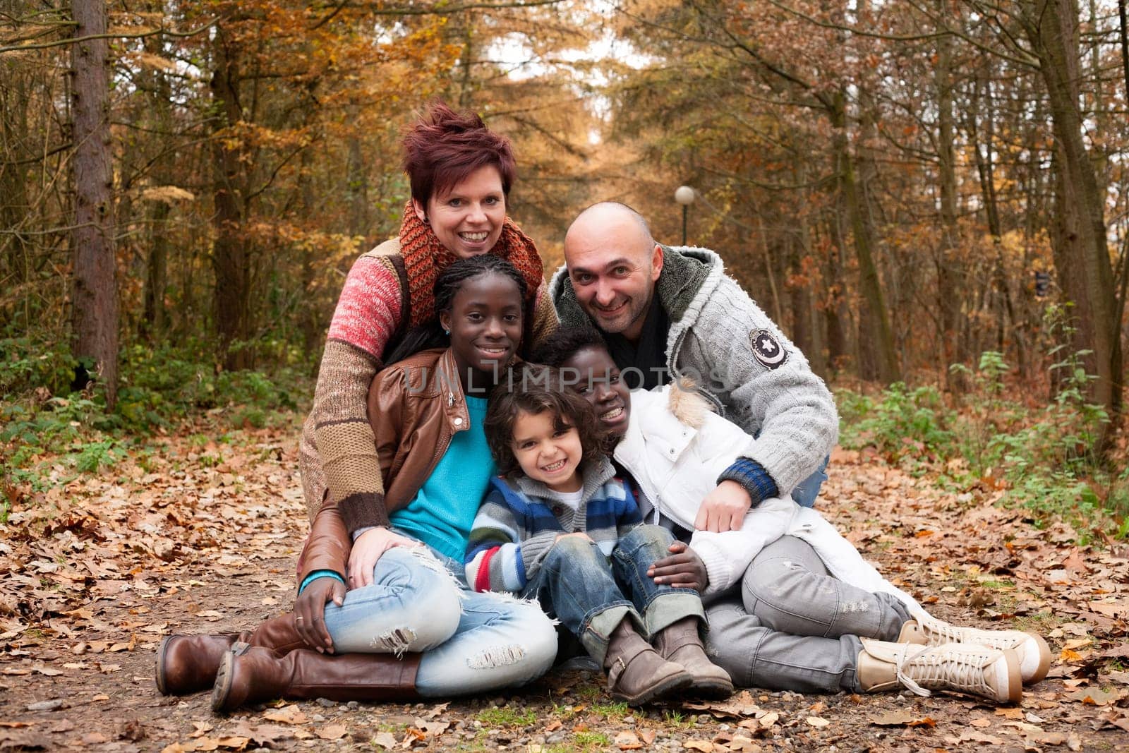 Happy family with foster children in the forest