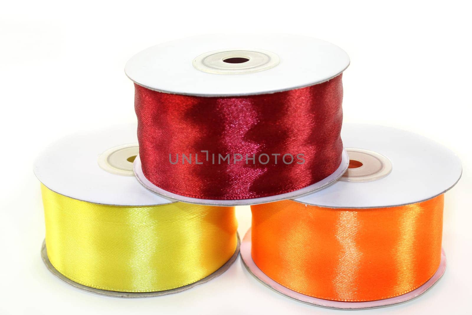 three rolls of ribbon against white background