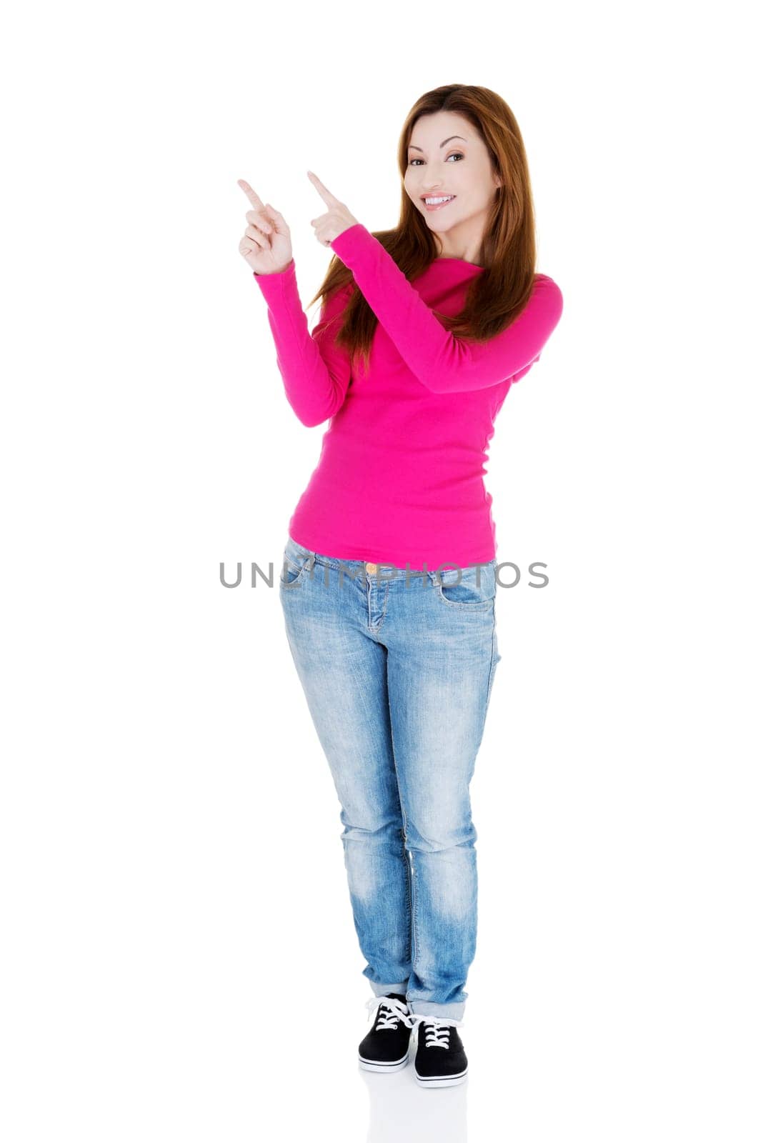 Happy , excited woman pointing on copy space, isolated on white