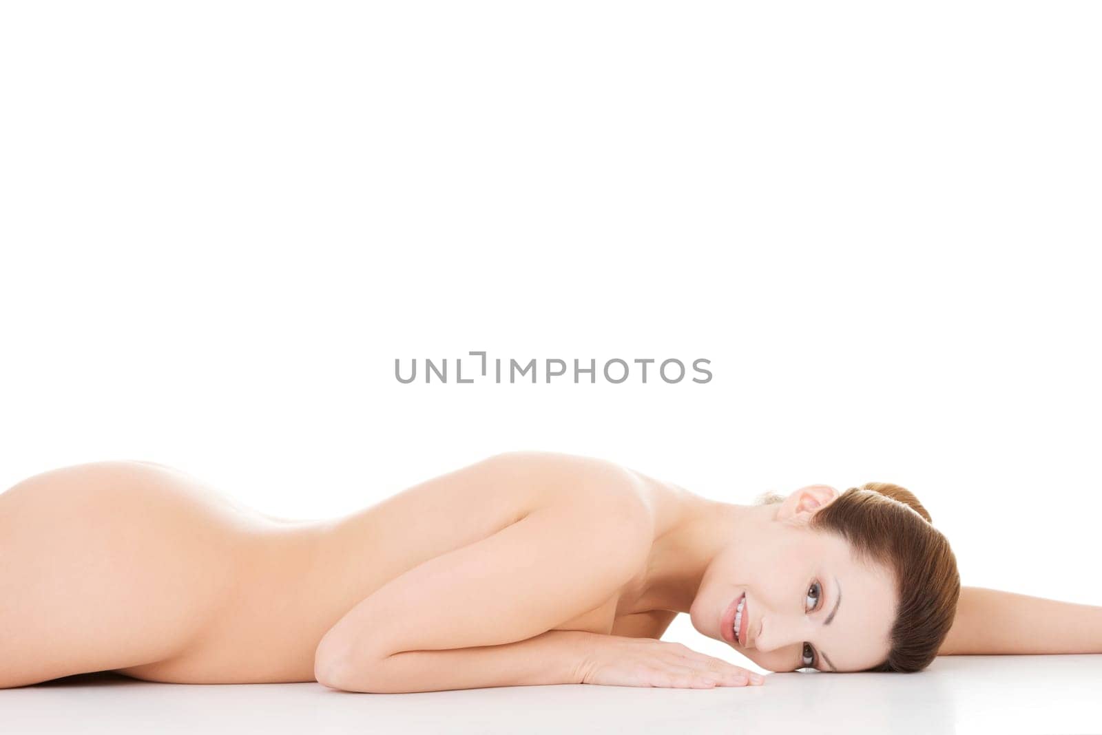 Sexy fit naked woman with healthy clean skin lying down, isolated on white