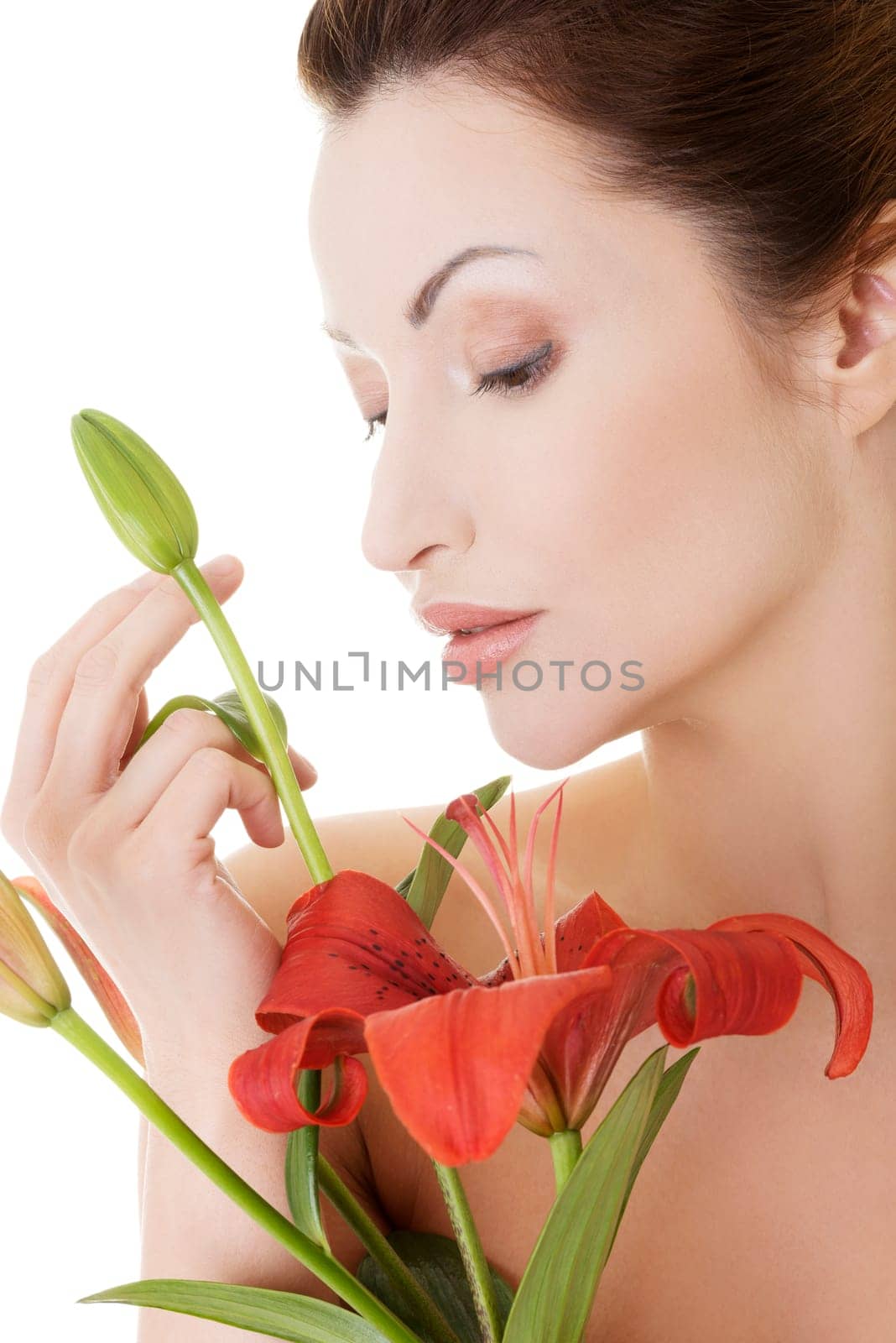 Portrait of beautiful adult woman with health skin and with red lily flower
