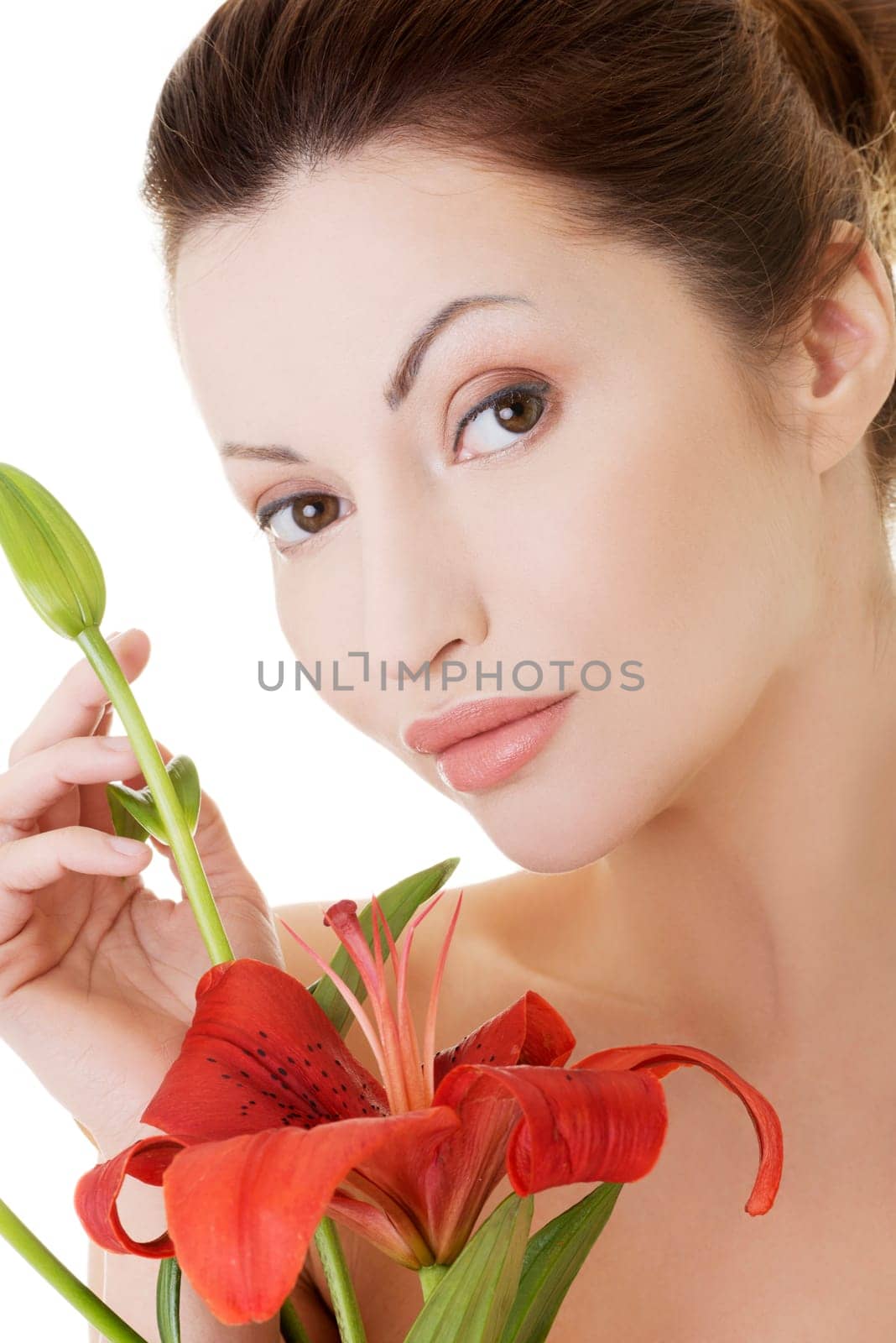 Portrait of beautiful adult woman with health skin and with red lily flower