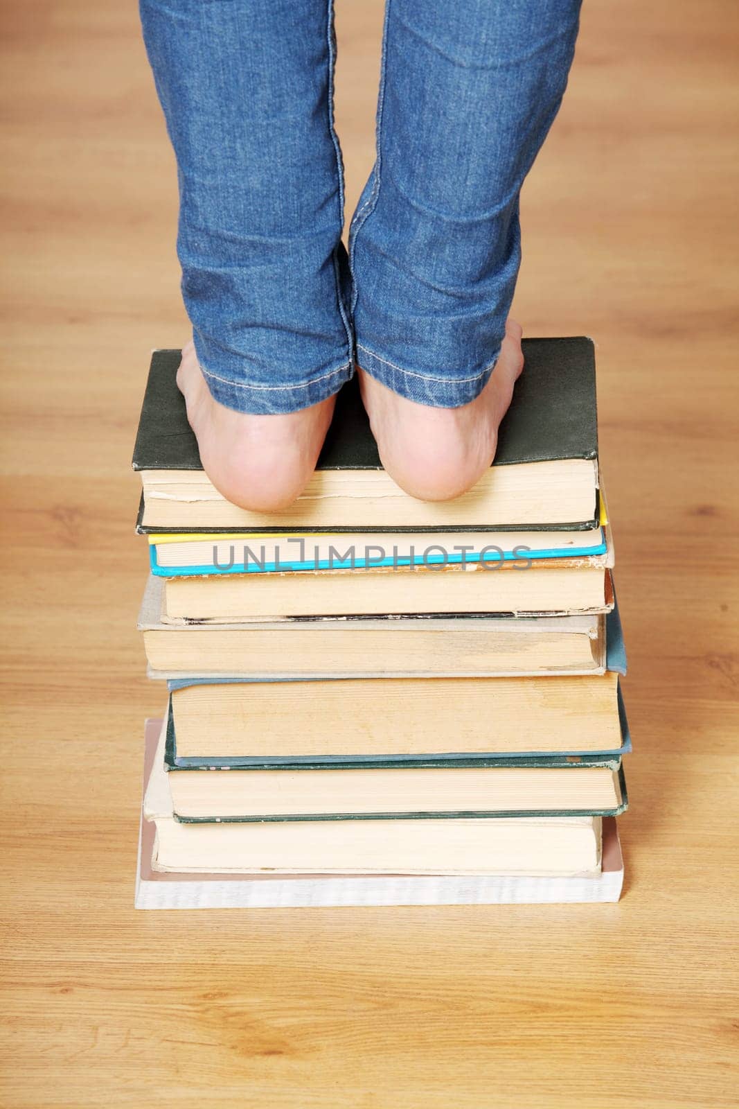 Girl standing on pile of books