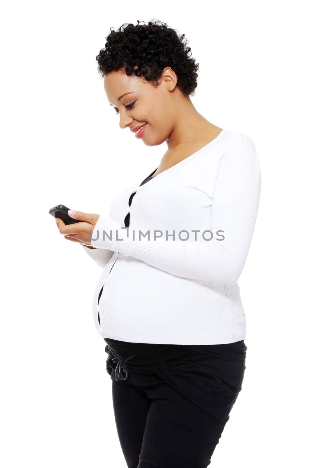 Beautiful pregnant woman dialing a number on her cellphone, isolated on a white background.
