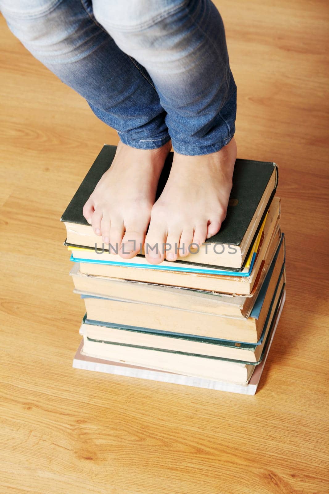 Girl standing on pile of books