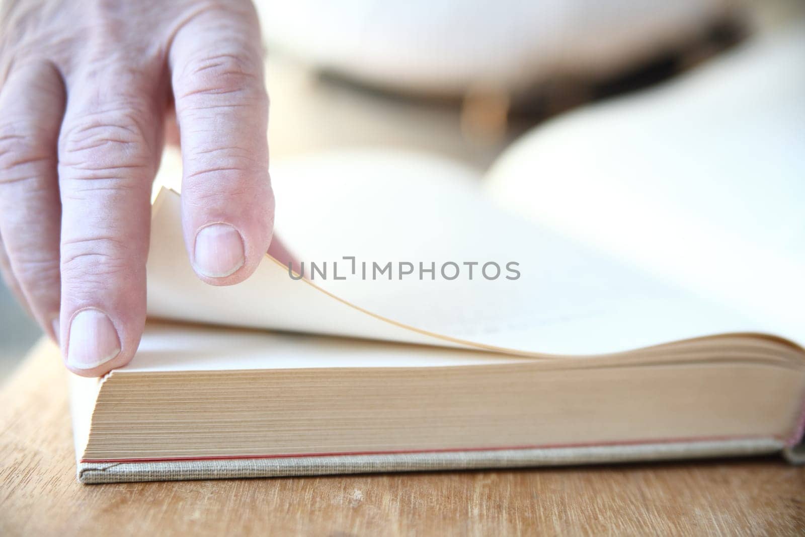 a man turns the pages of a large book
