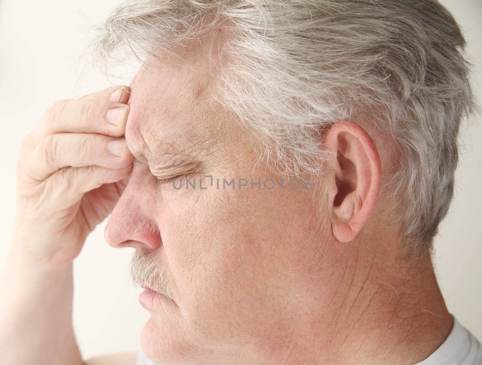 senior suffering from a bad headache centered near his eye