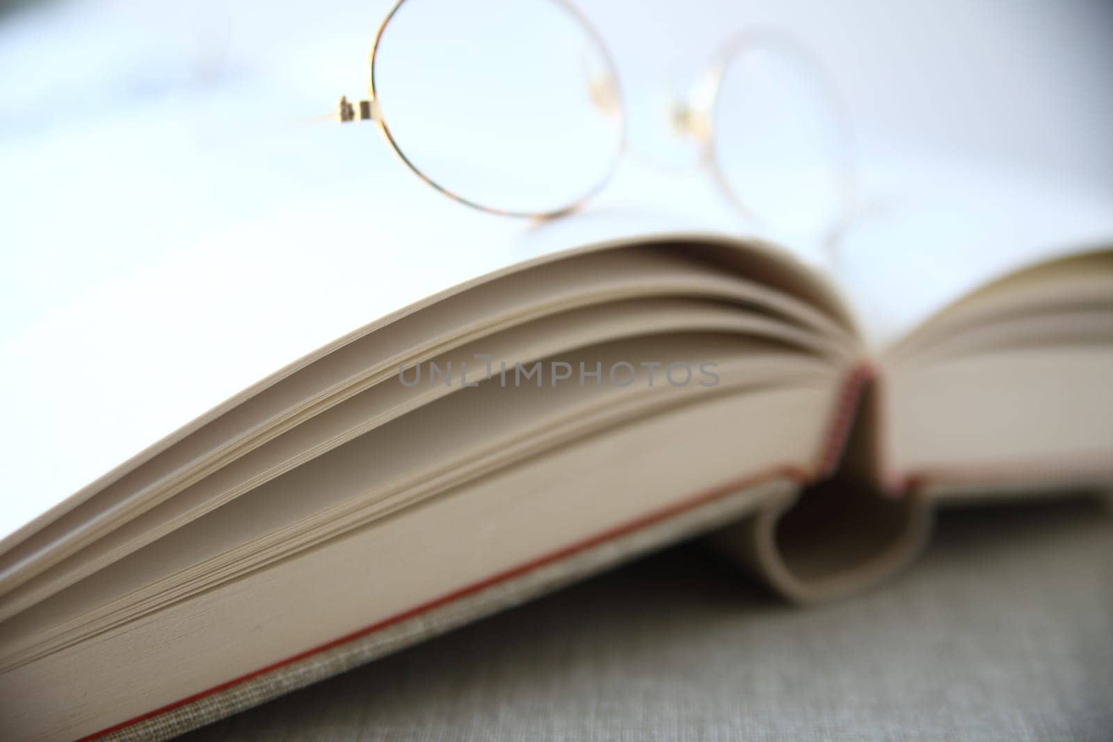 a pair of reading glasses rests on an open book