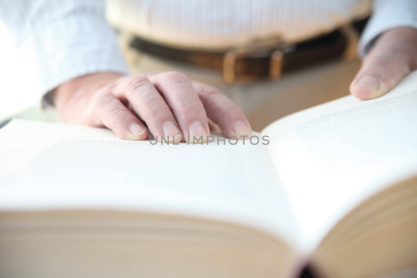 man with his hands on a large book