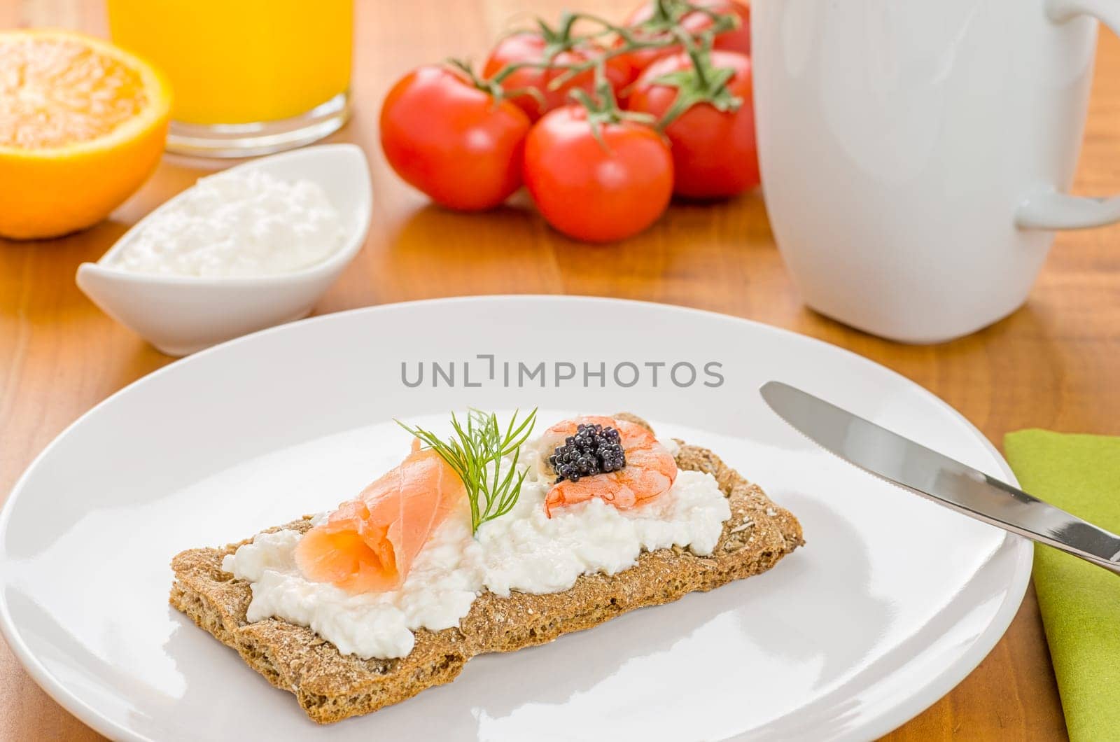 Crispbread with salmon and shrimp on a laid breakfast table