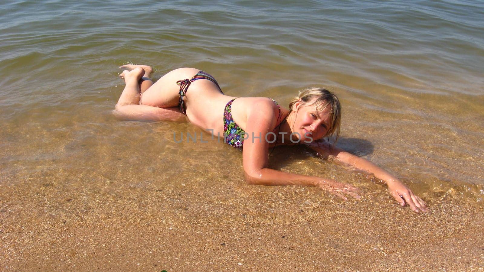 sympathetic girl lays on sand at the sea